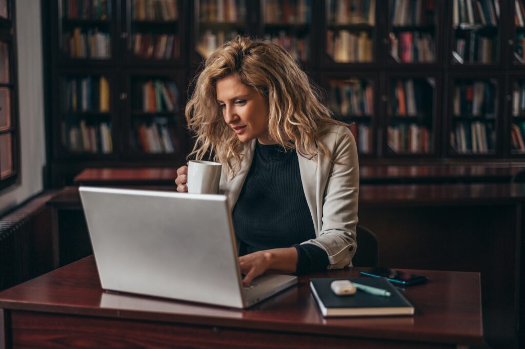 Businesswoman using a laptop and a business planner in an office